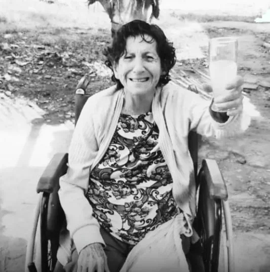 Eliane Lescaut sorridente em cadeira de rodas, moradora de Tamoios, Cabo Frio, avó de Anthony Lescaut